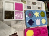 Saippuoihin lisättiin värejä ja tuoksuja sekä asetettiin muotteihin kovettumaan